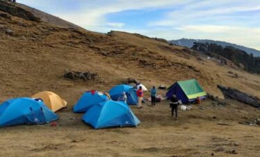 Camping at Bekaltal during Brahmatal trek in Uttarakhand without snow surrounded by forest