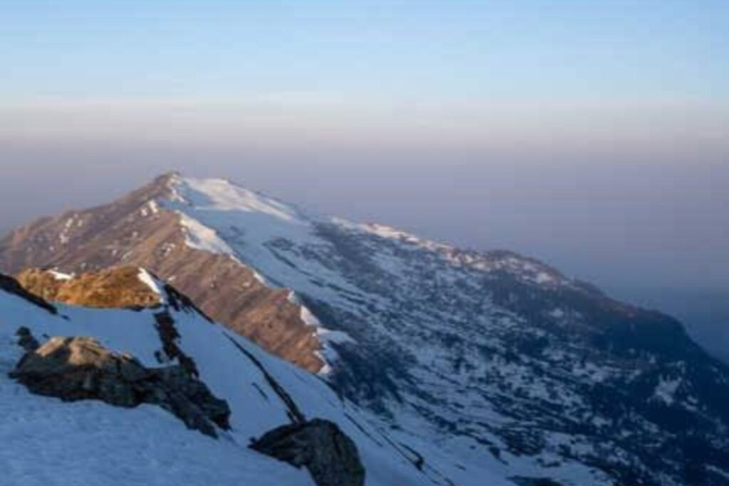 Dinnala Bugyal meadow on Aancha Top trek with Himalayan peaks background