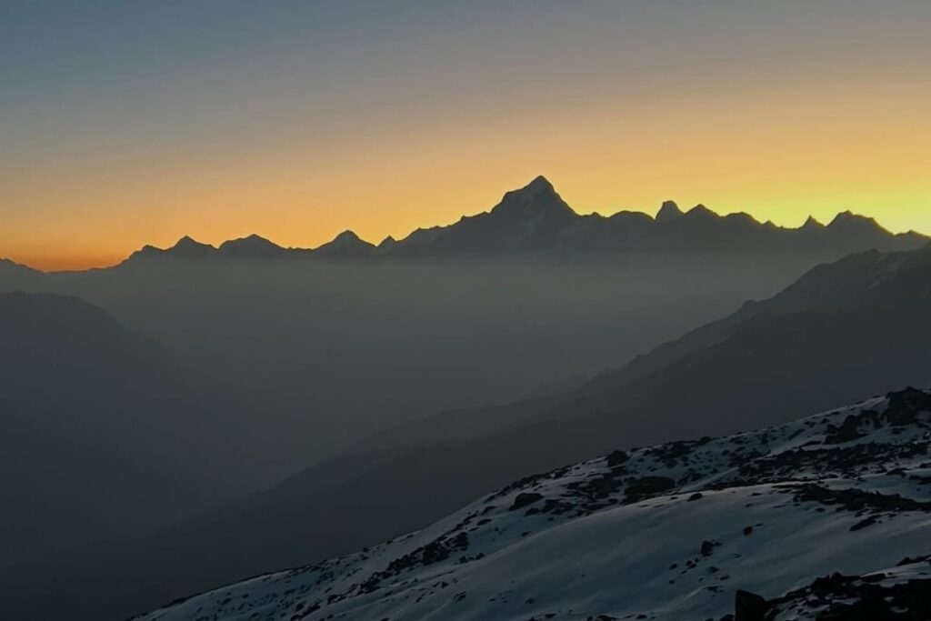 Golden sunset over snow-covered Himalayan peaks during Pangarchulla Trek in Uttarakhand