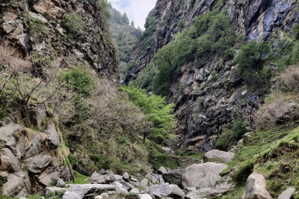 ascending towards Upper Kyarkoti through alpine meadows and rocky Himalayan terrain